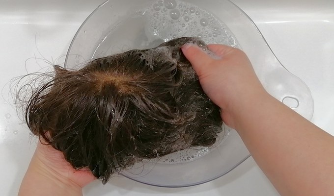 洗面ボウルでウィッグを手洗いする様子