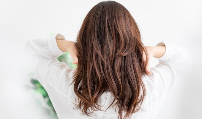 ロングヘアのウィッグを着用した女性の後ろ姿